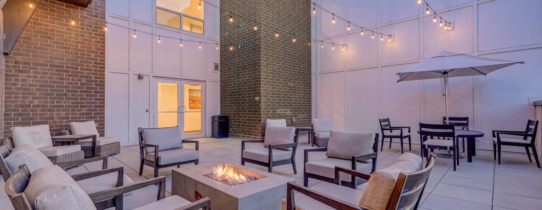 Rooftop terrace with fire pit and lights at Sequoia at Turner Mill